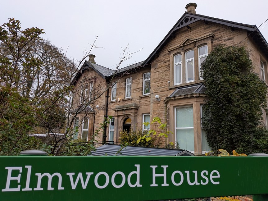 A building with a sign in front saying 'Elmwood House'