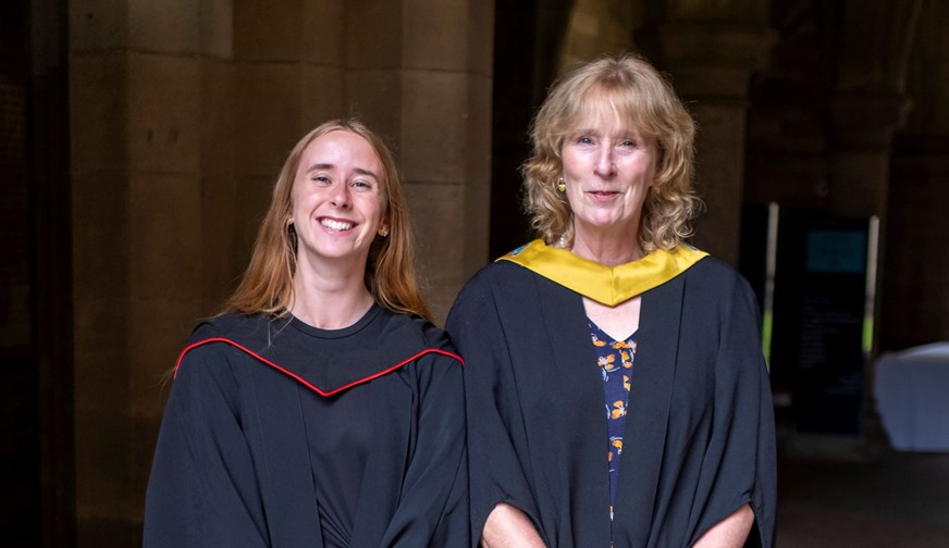 Two women in graduation robes.