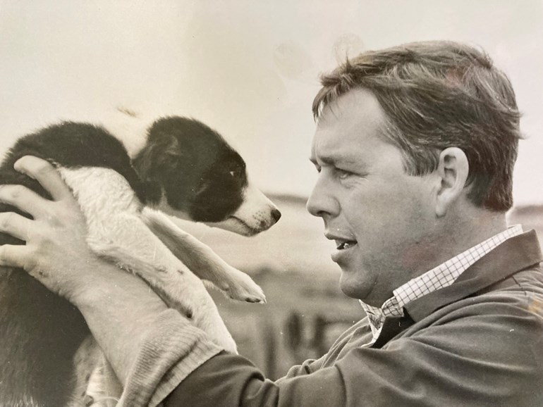 Black and white photo of a man with a puppy