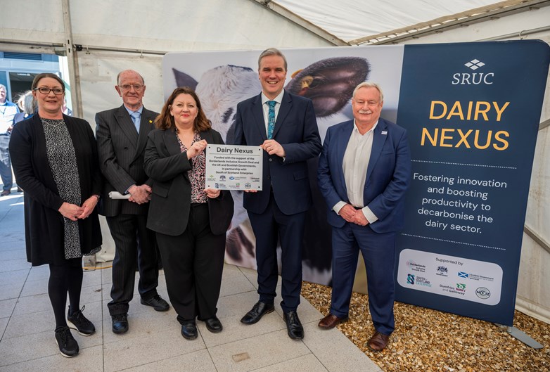 Five people pose for a photo with a plaque.