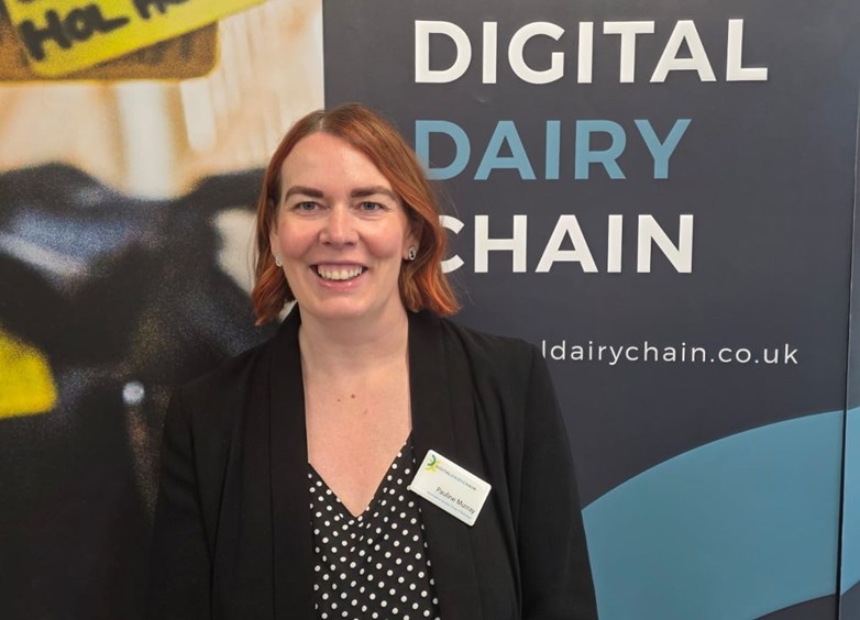 Woman standing in front of a background with the text 'DIGITAL DIARY CHAIN'