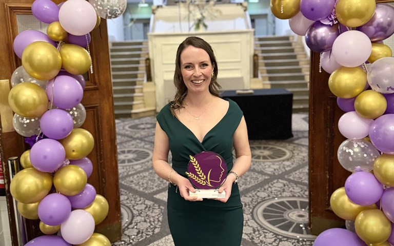 A woman holding a trophy